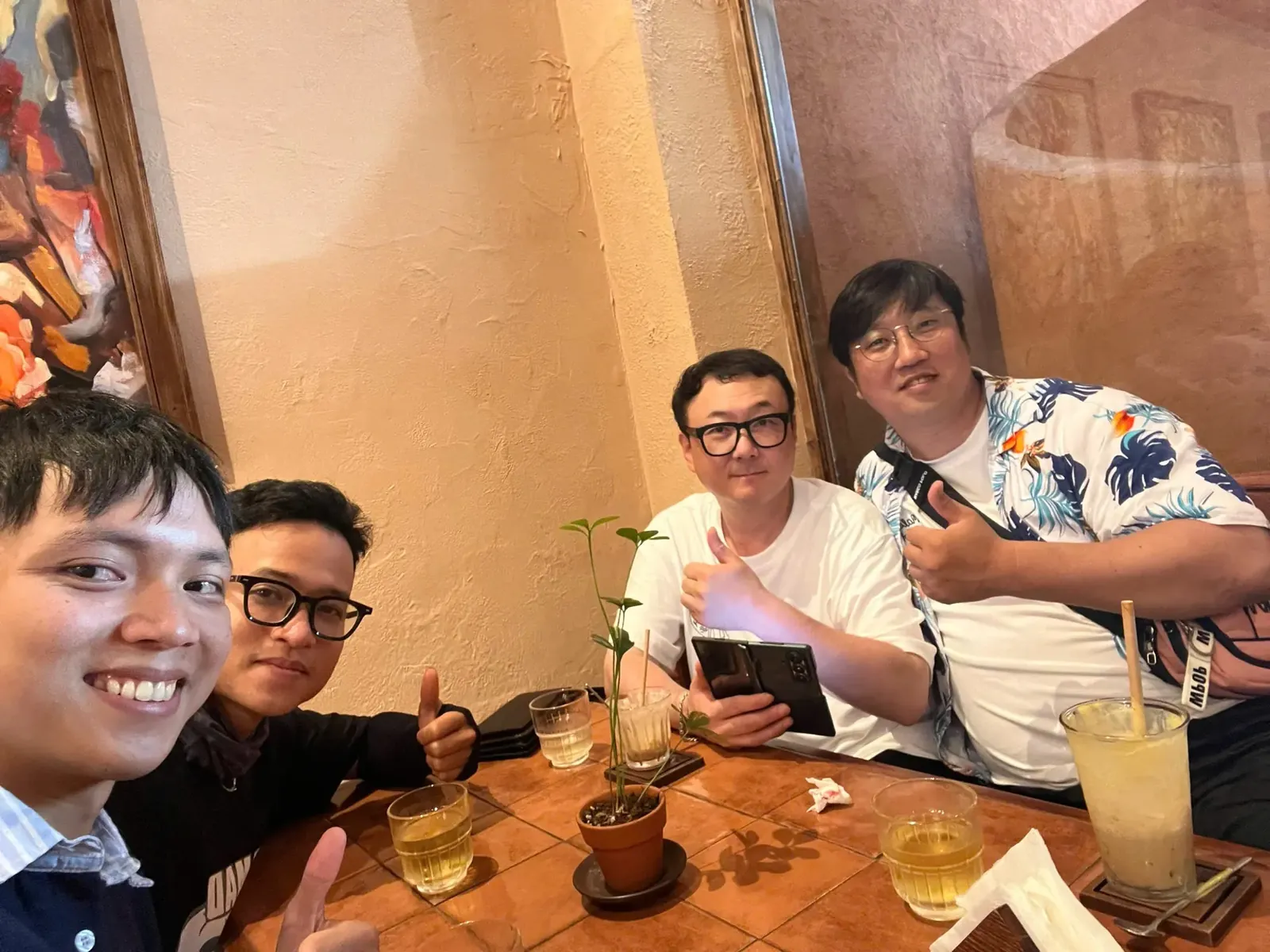 Guests and their guide with coffee and drinks at a café table in Da Nang